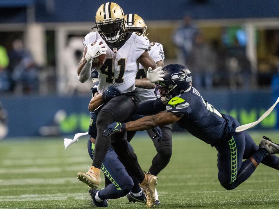 Alvin Kamara breaks through a tackle against the Seattle Seahawks.