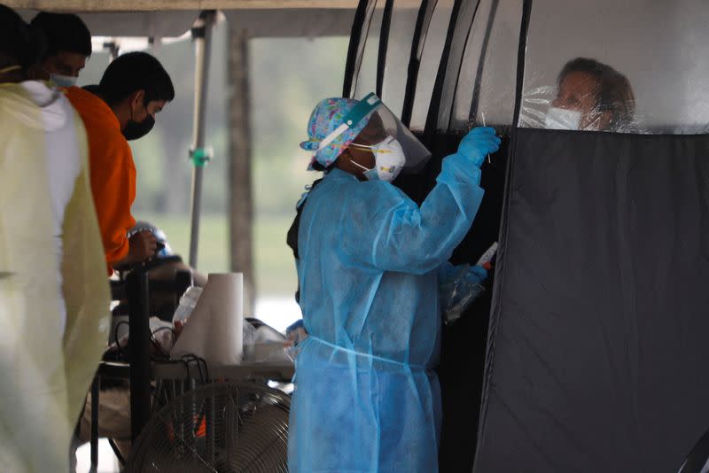 A healthcare worker carries out tests for the coronavirus disease (COVID-19) at a testing center in Dolphin Mall, in Miami