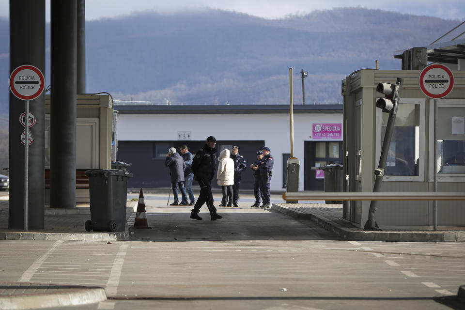 Serbian police officers stand at the closed Merdare border crossing between Kosovo and Serbia on Wednesday, Dec. 28, 2022. Kosovo closed the border crossing in Merdare, following an erected barricade by Serb protesters inside Serbia late Tuesday night, the third official border crossing closed this month following rising tensions between Kosovo and Serbia. (AP Photo/Visar Kryeziu)