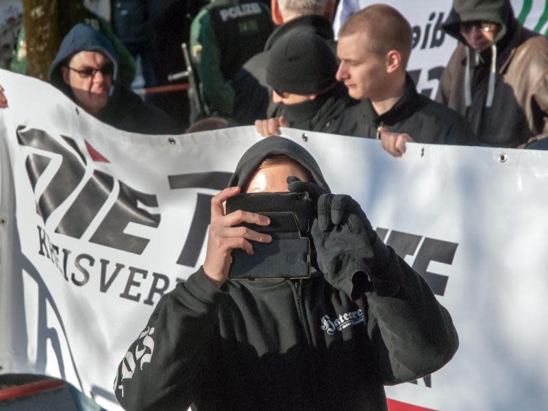 Ein Demonstrant der rechten Szene fotografiert vor dem Gericht Gegendemonstranten. Foto: Aren Kamm