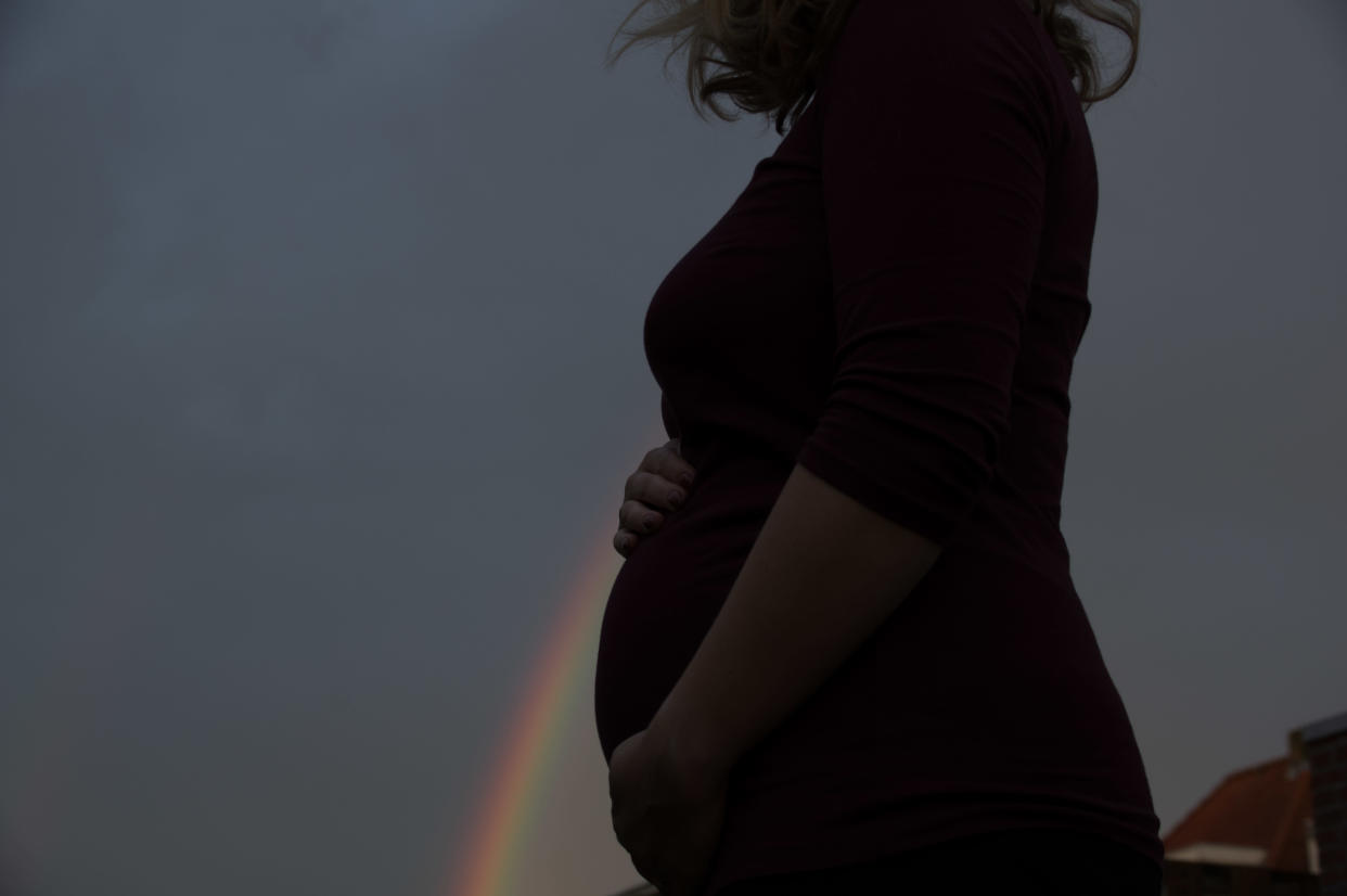 Pregnant woman in perspective with a rainbow
