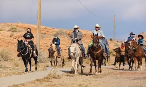 A group of Native Americans on the Navajo Nation ride on horseback to the polls on election day in Kayenta, Arizona.