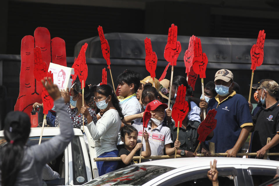 Protesters hold large three-fingered salute cutouts while onboard a vehicle in Yangon, Myanmar on Monday, Feb. 8, 2021. Tension in the confrontations between the authorities and demonstrators against last week's coup in Myanmar boiled over Monday, as police fired a water cannon at peaceful protesters in the capital Naypyitaw. (AP Photo)