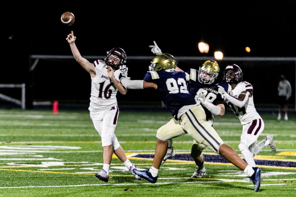Appoquinimink's Greg Nielsen (16) throws under pressure by Salesianum's Ahmaad Foster (92) and Nathaniel Ray (89) during the Jaguars' 30-20 victory at Abessinio Stadium on Saturday night.
