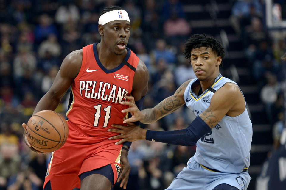 ARCHIVO - En esta foto de archivo dle 20 de enero de 2020, Jrue Holiday, de los Pelicans de Nueva Orleáns, controla el balón frente a Ja MOrant, de los Grizzlies de Memphis (AP Foto/Brandon Dill, archivo)