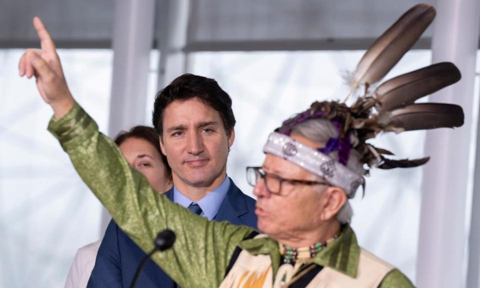 Ka’nahsohon Kevin Deer, a First Nations Elder, performs a ceremony as the Canadian prime minister, Justin Trudeau, looks on.