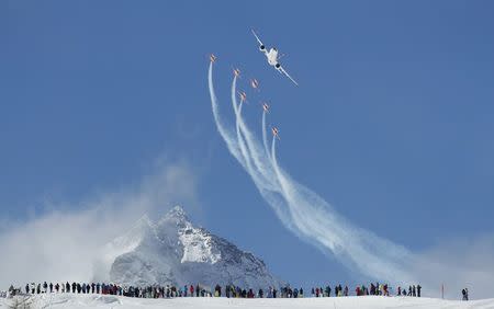 Members of the Swiss aerobatic team Patrouille Swiss fly in formation with a Swiss Bombardier CS100 over the men's Alpine Skiing World Championships in St. Moritz, Switzerland, February 11, 2017. REUTERS/Denis Balibouse