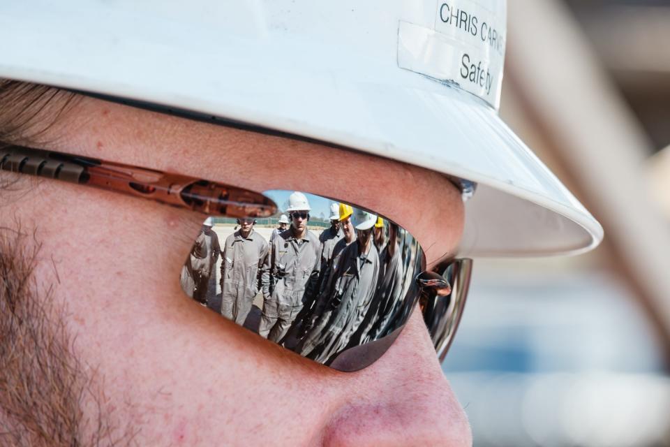 Buckeye Career Center Energy Operations and Natural Resources students are reflected in the glasses of Chris Carver, Senior EHS Representative, during a learning tour of the Encino Energy Leeper rig and well pad on Thursday in Sherrodsville. Carver was one of four safety personnel charged with giving tours.