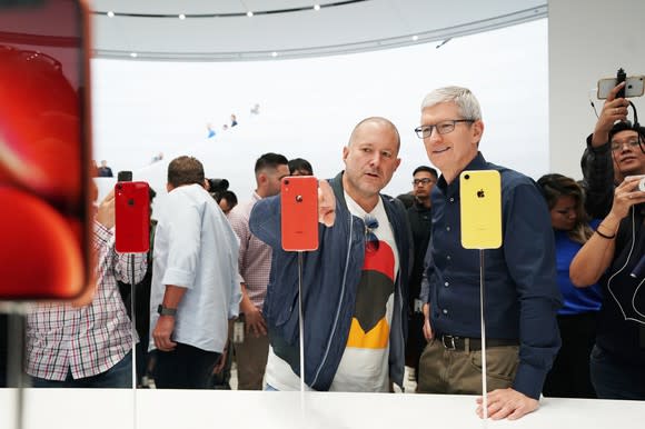 Apple executives Tim Cook and Jony Ive looking at the iPhone XR