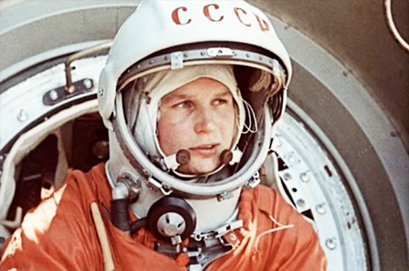 Soviet cosmonaut Valentina Tereshkova wearing an orange flight suit and helmet.