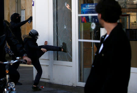 Un joven rompe una ventana durante una manifestación del movimiento de los "chalecos amarillos" en Nantes, Francia. 16 de febrero, 2019. REUTERS/Stephane Mahe