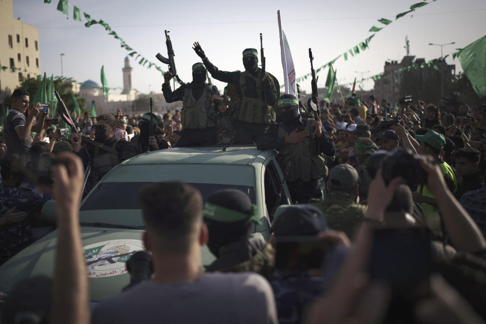 Numerosos palestinos presencian un desfile de combatientes del grupo armado Hamas en Beit Lahia, norte de la Franja de Gaza, el domingo 30 de mayo de 2021. (AP Foto/Felipe Dana)