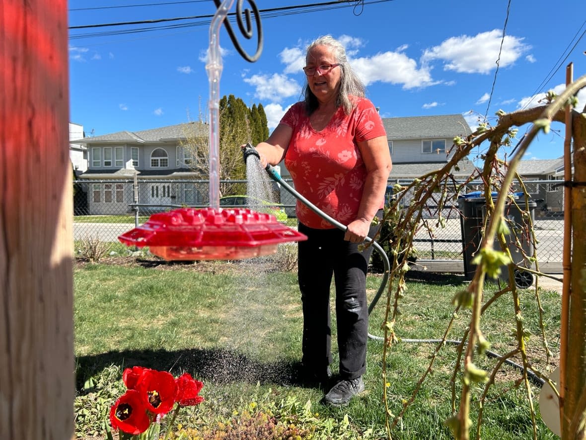Merritt, B.C., resident Linda Warner waters her plants by hand on April 22, 2024, as required by city watering restrictions.  (Julie Landry/Radio-Canada - image credit)