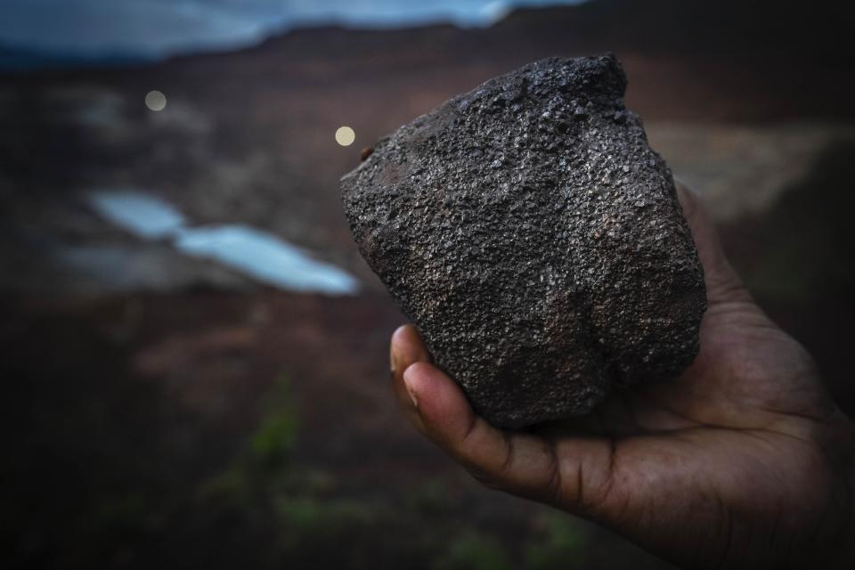 A mining engineer shows a piece of chromium ore at a mine near Kaliapani village in Jajpur district, Odisha, India on Wednesday, July 5, 2023. Chromium, used mostly as a coating to stop rust in steel and car parts, has been deemed necessary for India's transition to cleaner energy. (AP Photo/Anupam Nath)