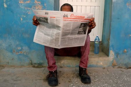 A man reads the daily newspaper Granma in Havana, Cuba, July 21, 2018. The lead on the frontpage reads "The capitalism will never come back to Cuba". REUTERS/ Stringer