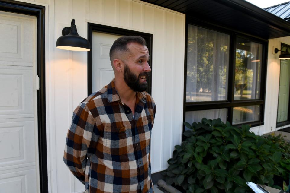 Realtor Kenny Mayle talks outside a Lake Township home that has been remodeled in a modern farmhouse style.