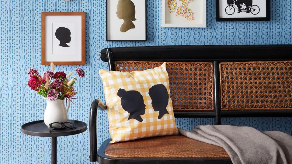 a blue wallpapered wall decorated with framed silhouettes