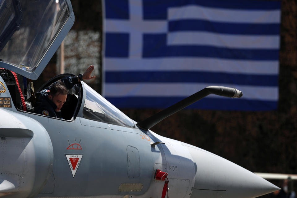 A Greek pilot of a Mirage 2000-5 gives directions to a ground crew member at Andravida air base, about 279 kilometres (174 miles) southwest of Athens, Tuesday, April 20, 2021. Greece vowed Tuesday to expand military cooperation with traditional NATO allies as well as Middle Eastern powers in a race to modernize its armed forces and face its militarily assertive neighbor Turkey. (AP Photo/Thanassis Stavrakis)