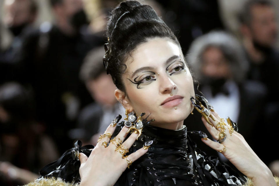 Isabelle Boemeke with dramatic eye liner and jeweled fingers and fingernails