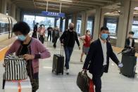 Travellers arrive at a train station ahead of China's upcoming Golden Week holiday following the coronavirus disease (COVID-19) outbreak, in Beijing