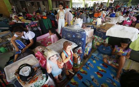 Residents take shelter at a basketball covered court after they were evacuated at the height of Typhoon Kalmaegi in Marikina, Metro Manila September 15, 2014. REUTERS/Erik De Castro