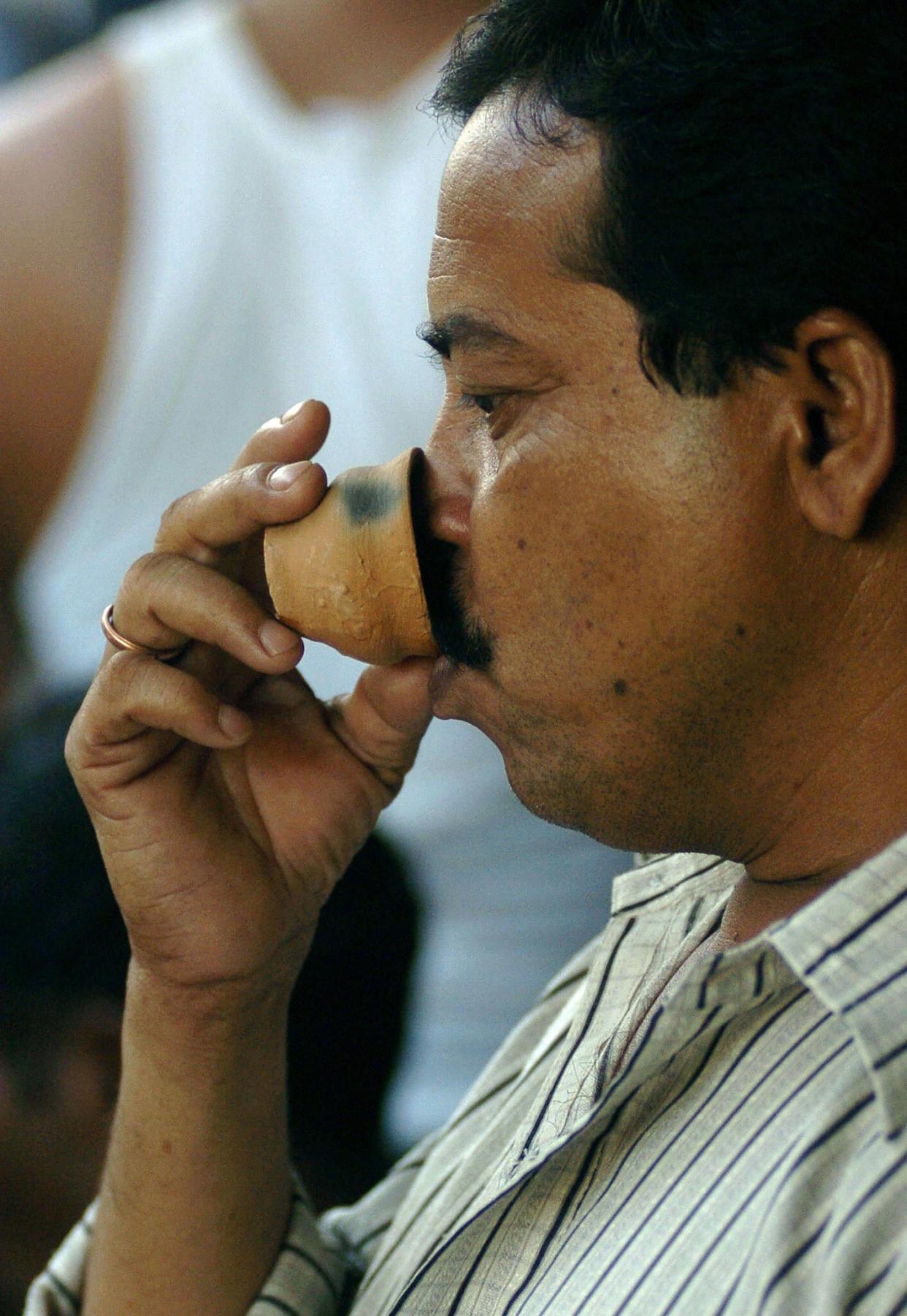 <p>File: An Indian man drinks tea from an earthenware cup</p> (AFP via Getty Images)