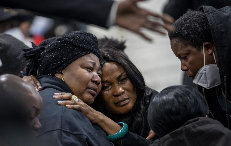 Patrick Lyoya's mother, Dorcas Lyoya, left, is embraced during the funeral for Patrick Lyoya at the Renaissance Church of God in Christ Family Life Center, Friday, April 22, 2022 in Grand Rapids, Mich. The Rev. Al Sharpton demanded that authorities publicly identify the Michigan officer who killed Patrick Lyoya, a Black man and native of Congo who was fatally shot in the back of the head after a struggle, saying at Lyoya's funeral Friday: “We want his name!" (Cory Morse/The Grand Rapids Press via AP)