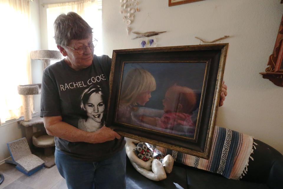 Janet Cooke shows a painting of her daughters JoAnn and Rachel that hangs at her home.