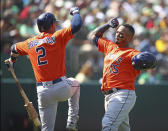 Houston Astros' Martin Maldonado, right, celebrates with Alex Bregman (2) after hitting a home run off Oakland Athletics' Emilio Pagan in the seventh inning of a baseball game Sunday, Aug. 19, 2018, in Oakland, Calif. (AP Photo/Ben Margot)