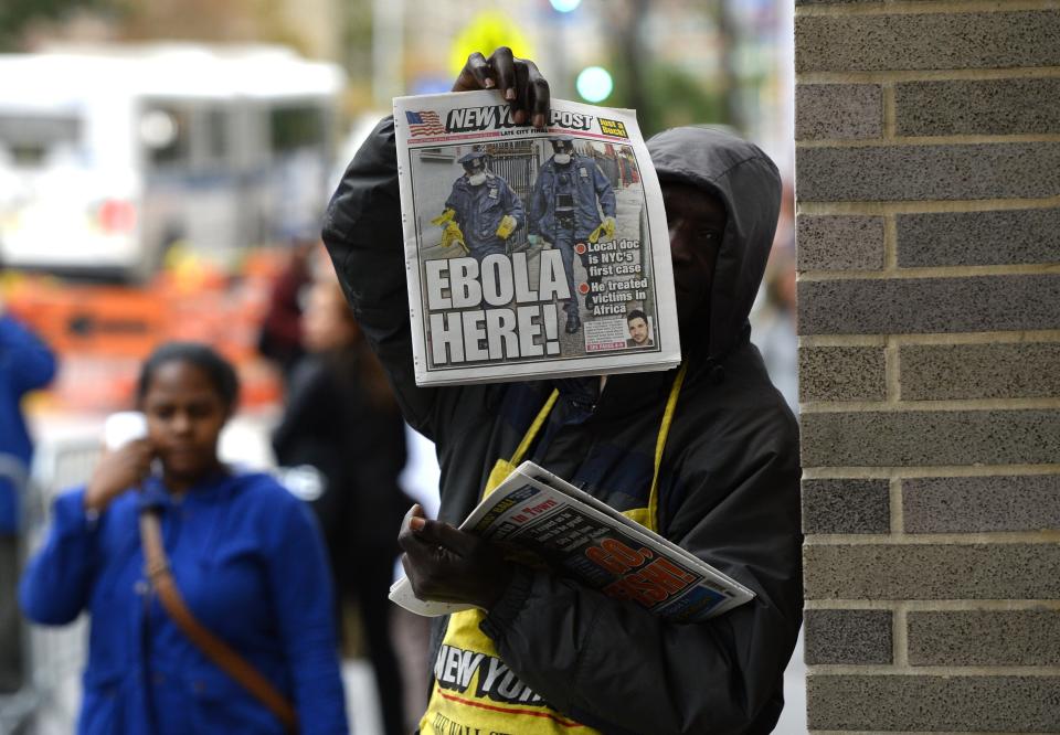 A newspaper vendor holds up a copy of the NY Post in front of the entrance to  Bellevue Hospital October 24, 2014 in New York, the morning after it was confirmed that Craig Spencer, a member of Doctors Without Borders, who recently returned to New York from Guinea tested positive for Ebola.