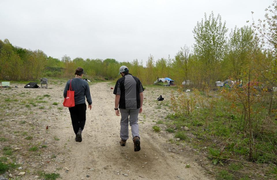 Outreach caseworker Sarah Schwartz and Kevin Delfino, a medical resident, walk through the homeless encampment on Thursday.