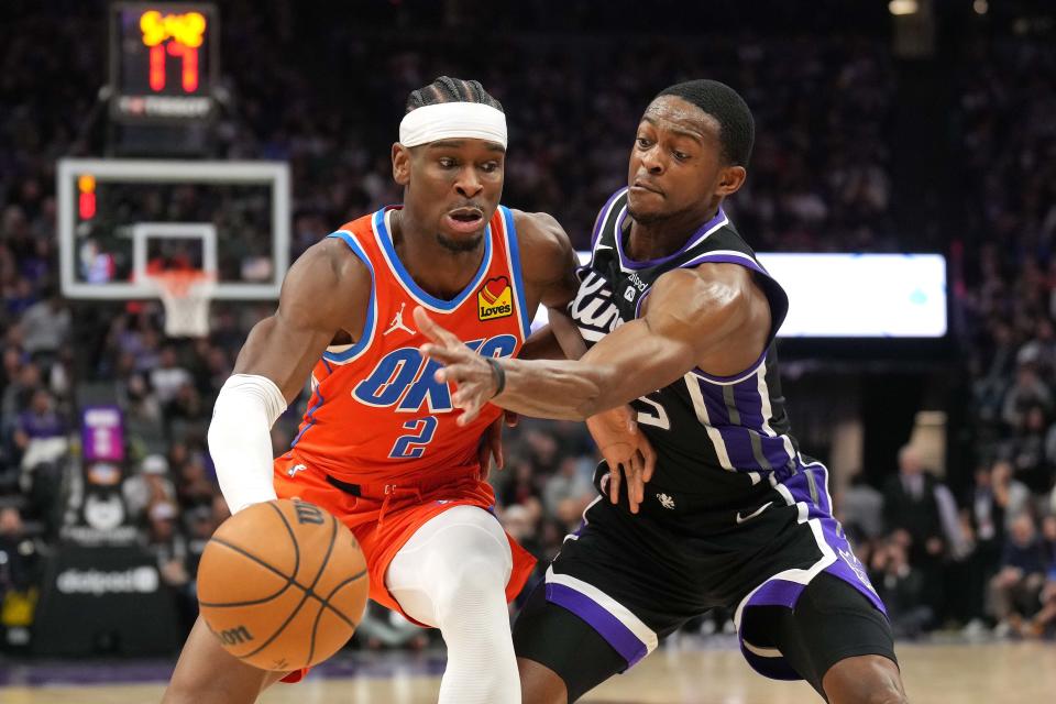 Dec 14, 2023; Sacramento, California, USA; Oklahoma City Thunder guard Shai Gilgeous-Alexander (2) dribbles against Sacramento Kings guard De'Aaron Fox (right) during the fourth quarter at Golden 1 Center. Mandatory Credit: Darren Yamashita-USA TODAY Sports