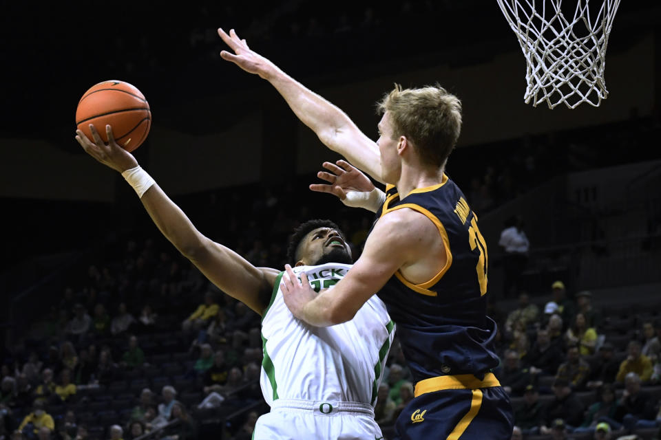 Oregon forward Quincy Guerrier shoots as California forward Lars Thiemann (21) defends during the first half of an NCAA college basketball game Thursday, March 2, 2023, in Eugene, Ore. (AP Photo/Andy Nelson)