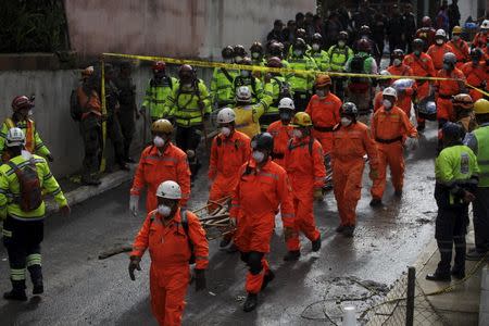 Rescue workers walk towards an area affected by a mudslide in Santa Catarina Pinula, on the outskirts of Guatemala City, October 5, 2015. REUTERS/Jose Cabezas