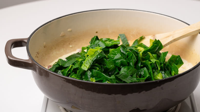 adding greens to a pan