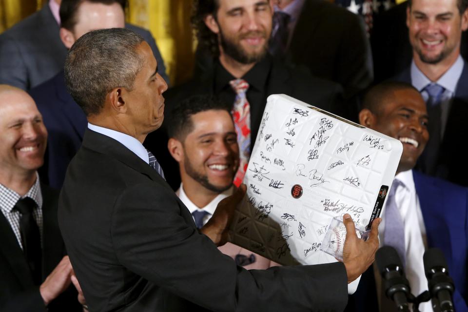 U.S. President Barack Obama holds an autographed base he was given as he plays host to a reception for the San Francisco Giants, Major League Baseball's 2014 World Series champions, in the East Room of the White House in Washington, June 4, 2015. REUTERS/Jonathan Ernst