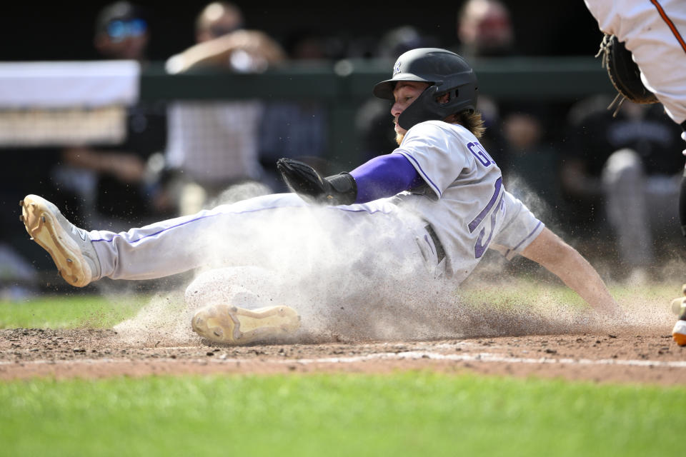 Colorado Rockies' Hunter Goodman slides towards home to score on a ground out by Elias Diaz during the ninth inning of a baseball game against against the Baltimore Orioles, Sunday, Aug. 27, 2023, in Baltimore. The Rockies won 4-3. (AP Photo/Nick Wass)