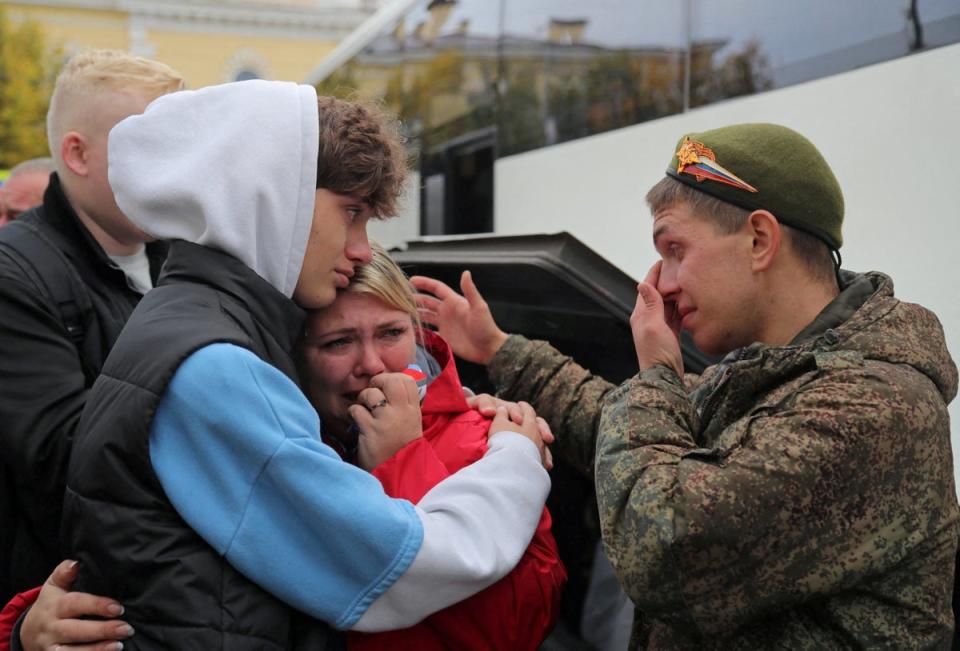 A Russian reservist bids farewell to relatives before his departure for a base in the course of partial mobilisation of troops (Reuters)