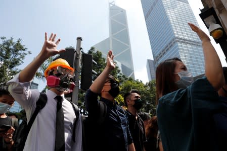 Anti-government office workers wearing masks attend a lunch time protest, after local media reported on an expected ban on face masks under emergency law, at Central, in Hong Kong