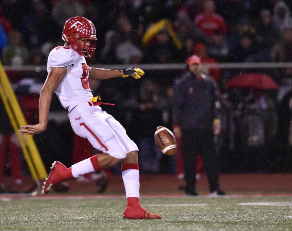 Fairfield's Erick All punts the ball against Coelrain as the rain began to fall Friday, Oct. 19, 2018 at Colerain High School