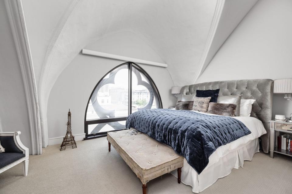 A condo at Meridian Arch, in the converted former Meridian Street Methodist Episcopal Church, 802 N. Meridian St., features include soaring curved ceilings, arched moldings and distinctive quatrefoil tracery windows.