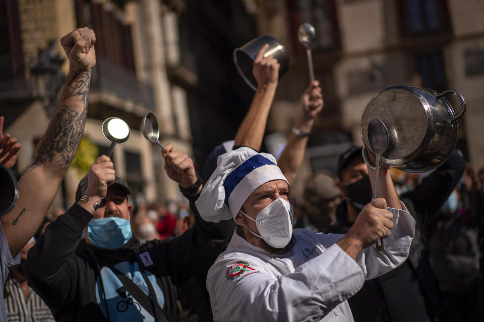 FILE - In this Friday, Oct. 16, 2020 file photo, workers of catering sectors take part in a protest organized by restaurants and bar owners in Barcelona, Spain. The coronavirus pandemic is gathering strength again in Europe and, with winter coming, its restaurant industry is struggling. The spring lockdowns were already devastating for many, and now a new set restrictions is dealing a second blow. Some governments have ordered restaurants closed; others have imposed restrictions curtailing how they operate. (AP Photo/Emilio Morenatti, File)