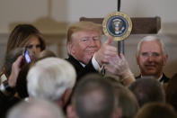 President Donald Trump, joined by Vice President Mike Pence, right, and first lady Melania Trump, left, gives the thumbs-up as he greets people during the Congressional Ball in the Grand Foyer of the White House in Washington, Saturday, Dec. 15, 2018. (AP Photo/Carolyn Kaster)