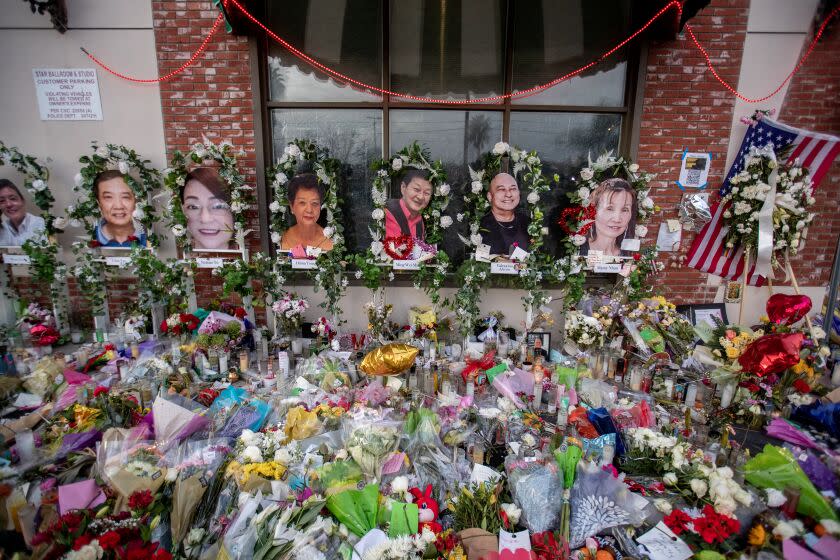 Monterey Park, CA - January 30: A photo of Wing Wei Ma, shown at center, owner of the Star Ballroom Dance Studio at a growing memorial for the 11 mass shooting victims in front of the Star Ballroom Dance Studio in Monterey Park Monday, Jan. 30, 2023. Ma hopes to carry on her father's legacy, and eventually reopen a dance studio like Star. (Allen J. Schaben / Los Angeles Times)