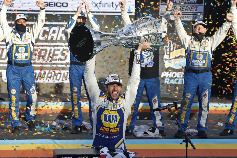 FILE - Chase Elliott holds up the season championship trophy as he celebrates with his race crew in Victory Lane after winning a NASCAR Cup Series auto race at Phoenix Raceway, Sunday, Nov. 8, 2020, in Avondale, Ariz. Chase Elliott wants to race cars. Fast cars that he can drive to a second NASCAR championship. The rest of the stuff? The crowds, the commercials, the showcasing his every move on social media? That’s just never going to be part of the job that Elliott finds enjoyable.(AP Photo/Ralph Freso, File)