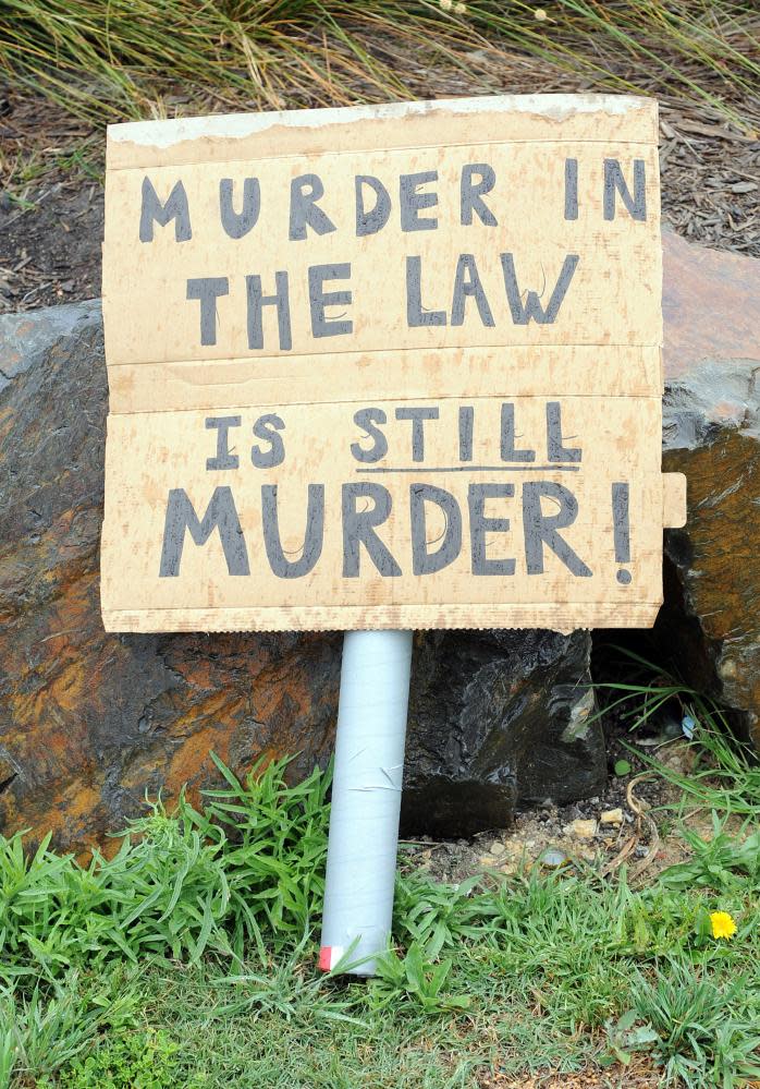 A placard is left at the scene where 15-year-old Tyler Cassidy was shot dead by police, behind a shopping centre in Northcote