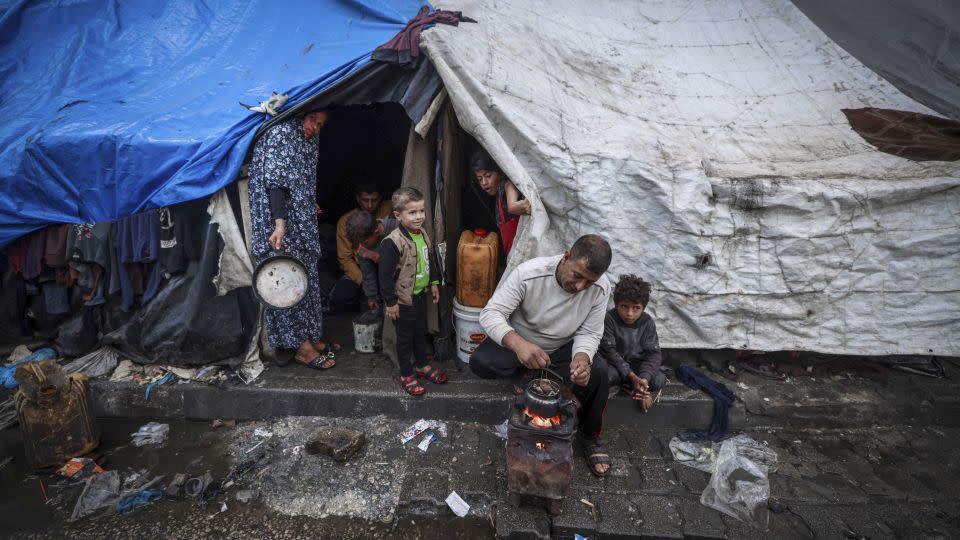 A displaced man makes tea outside his tent on Wednesday. Israel's war in Gaza has displaced most of the enclave's population. - Mohammed Abed/AFP/Getty Images