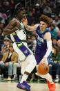 Charlotte Hornets' LaMelo Ball tries to get past Milwaukee Bucks' Jrue Holiday during the first half of an NBA basketball game Wednesday, Dec. 1, 2021, in Milwaukee. (AP Photo/Morry Gash)