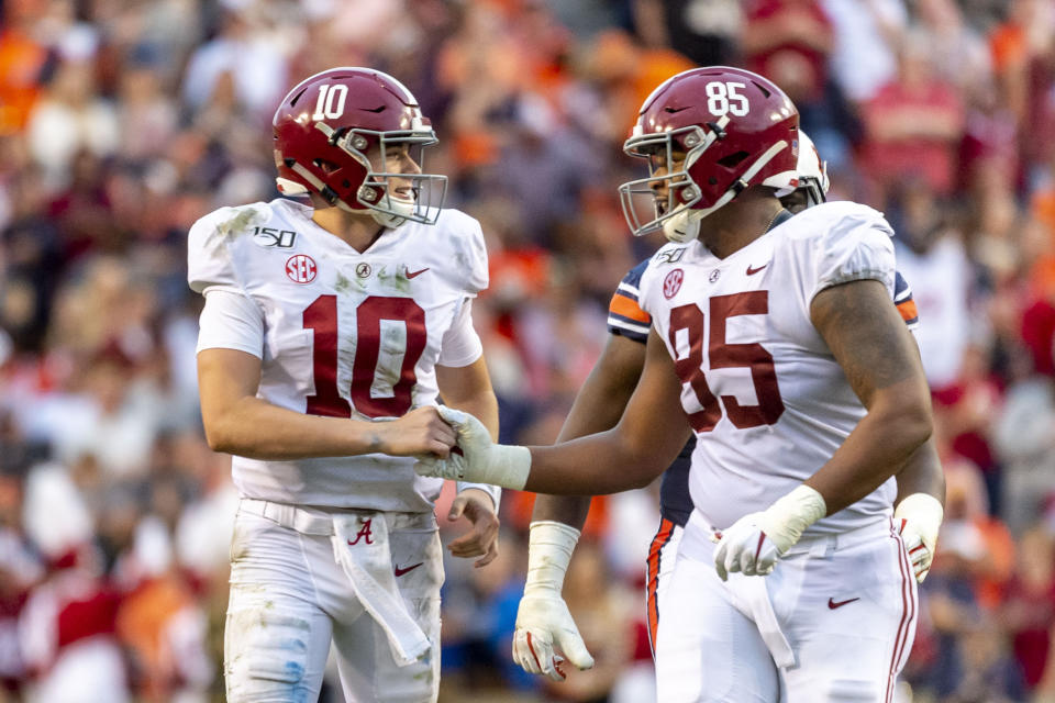 Alabama quarterback Mac Jones (10) and tight end Kendall Randolph (85) celebrate a touchdown during the first half of an NCAA college football game against Auburn, Saturday, Nov. 30, 2019, in Auburn, Ala. (AP Photo/Vasha Hunt)