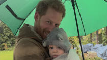 <p>Father and son sunggle under an umbrella. </p>